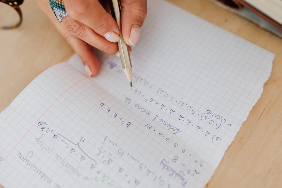 Handwritten maths working in a notebook